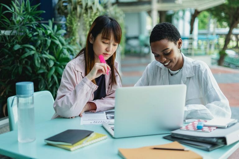 Two women look at a computer and work on a strategic planning process