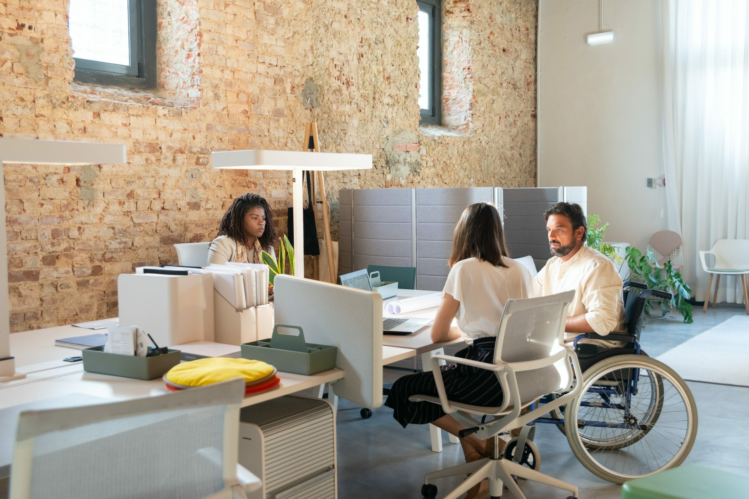 Three diverse employees sit around a table